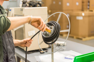 Alta employee wrapping sleeving, during production